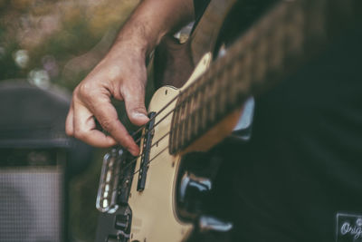 Midsection of man playing guitar