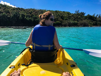 Rear view of woman sitting in boat on sea