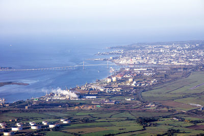 Aerial view of town by sea against sky