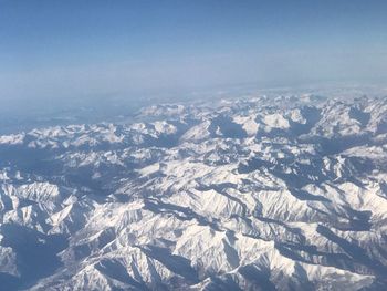 Aerial view of snowcapped mountains against sky