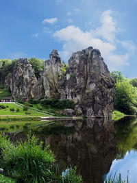 Scenic view of rock formation by trees against sky