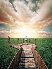 Rear view of person standing on wood against sky during sunset in tulum