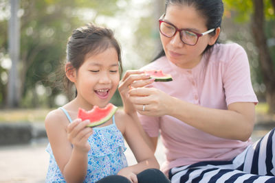 Mother and daughter eating watermelon