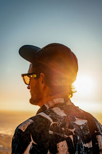 Side view of man standing against sky during sunset