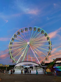 Ferris wheel in amusement park against sky