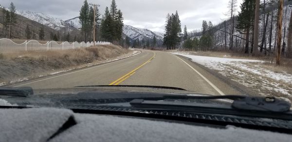 Road seen through car windshield during winter