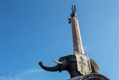 Low angle view of statue against clear blue sky