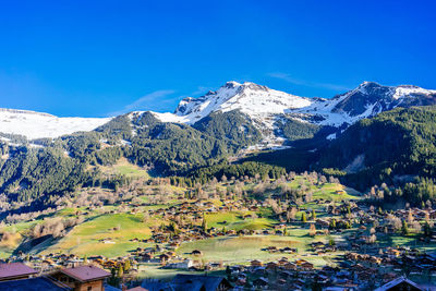 Scenic view of snowcapped mountains against blue sky