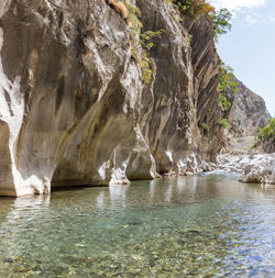 Scenic view of rock formation in water against sky