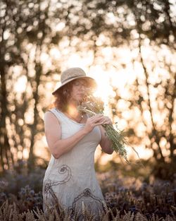 Woman wearing hat standing on field
