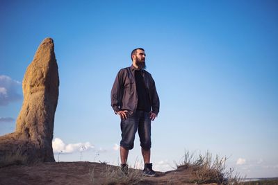 Full length of young man standing against clear blue sky