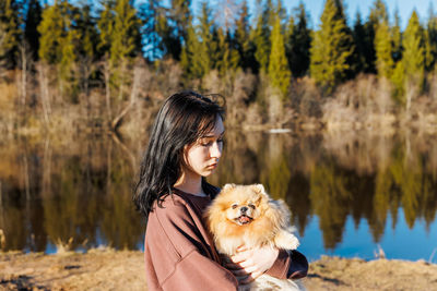 A girl walks with a dog in the park, outdoor recreation with a pet, a portrait with a small puppy