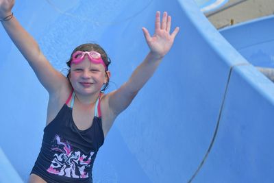 Girl sliding down on a water slide in aqua park. vacation concept. holiday fun