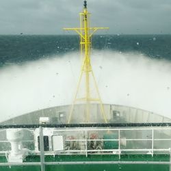 Close-up of yellow ship against sky