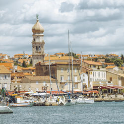 Buildings by river against sky