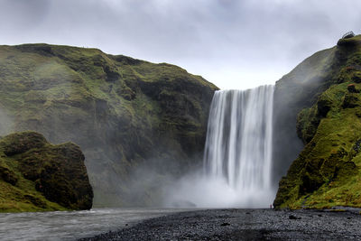 Scenic view of waterfall against sky