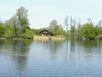 Scenic view of lake by building against sky