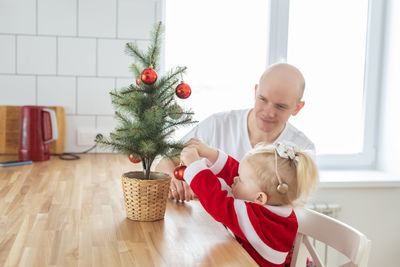 Portrait of boy playing with christmas tree at home