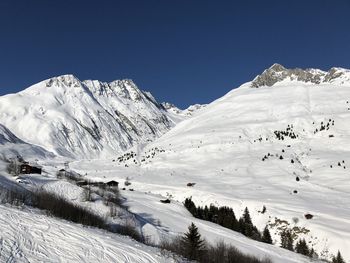 Scenic view of snowcapped mountains against clear blue sky