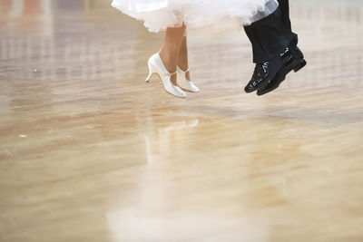 Low section of women dancing on hardwood floor