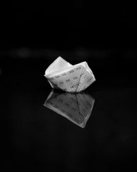 Close-up of paper ring on table against black background