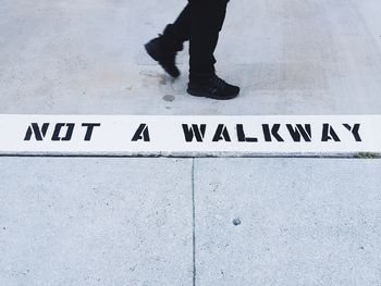 Low section of man walking on road