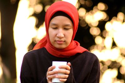 Close-up of young woman holding coffee cup