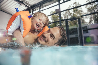 Happy father with daughter in indoor swimming pool