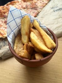 High angle view of potato wedges in container on table