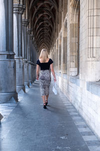 Full length rear view of woman walking in corridor