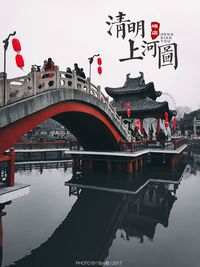 Reflection of bridge in water against clear sky