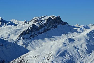 Scenic view of snowcapped mountains against clear blue sky