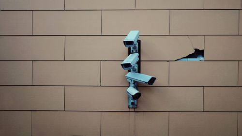 Full frame shot of surveillance camera on tiled wall