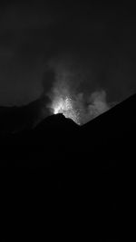 Low angle view of silhouette mountain against sky at night