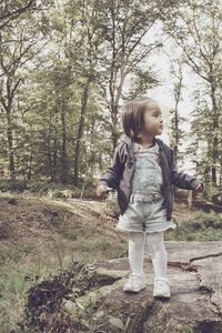 Full length of cute girl standing in forest