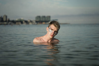 Portrait of man with make up on face standing in sea