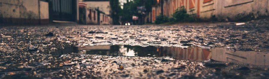 Reflection of building in puddle on street