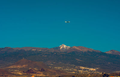 Aerial view of mountains against clear blue sky