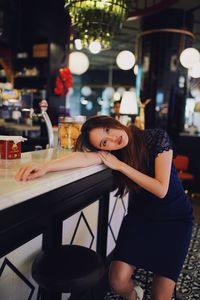Portrait of young woman with drink in restaurant
