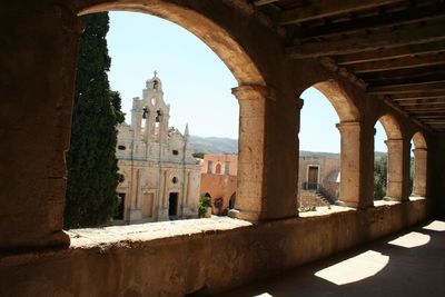 Buildings against sky seen through archway