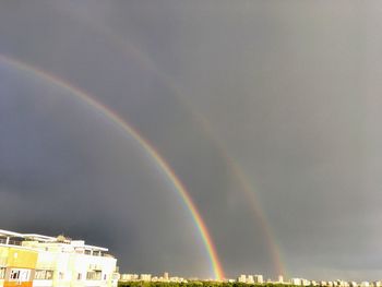 Low angle view of rainbow over buildings in city