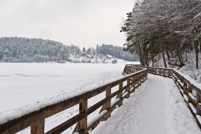 Snow covered footbridge on field
