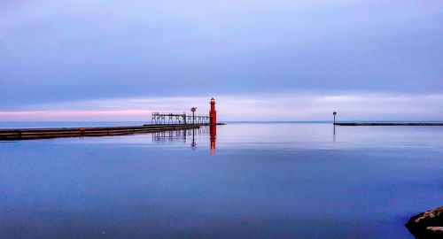 Pier on sea against sky during sunset