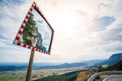 Low angle view of road mirror