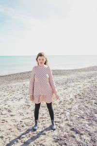 Woman standing on beach against sky