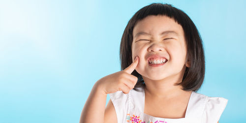 Portrait of smiling woman against blue background