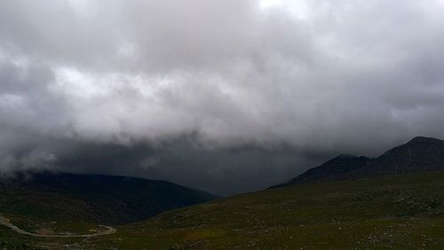 Scenic view of mountains against cloudy sky