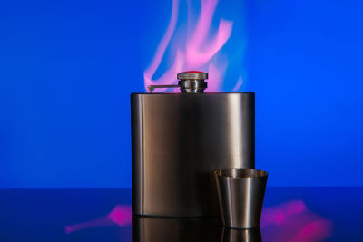 Close-up of electric lamp on table against blue background