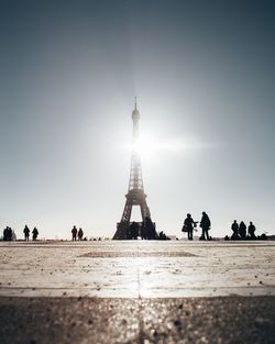 People in front of eiffel tower against clear sky