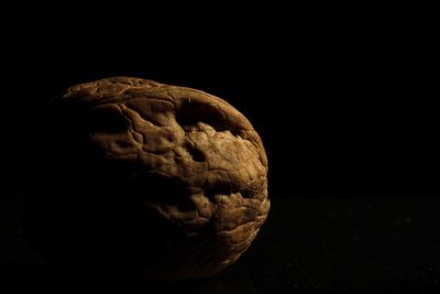 Close-up of bread on table against black background